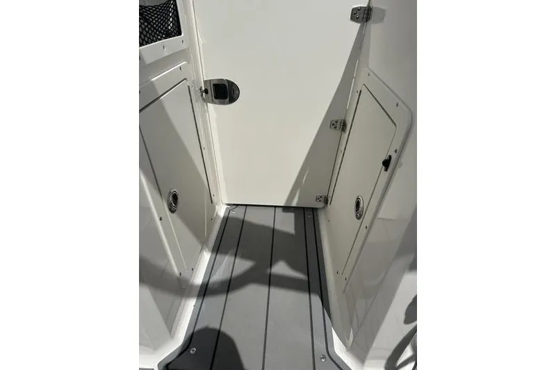 Slide: The Image of Interior view of 2021 Chaparral 21 Surf boat, featuring storage compartments and sleek flooring. - 2