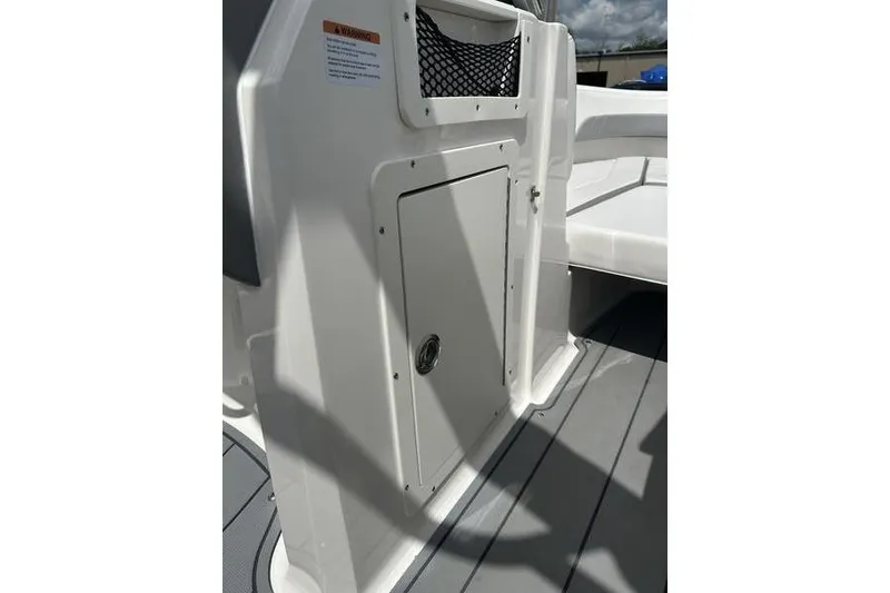 Slide: The Image of 2021 Chaparral 21 Surf boat interior with storage compartment and netted pocket. - 21