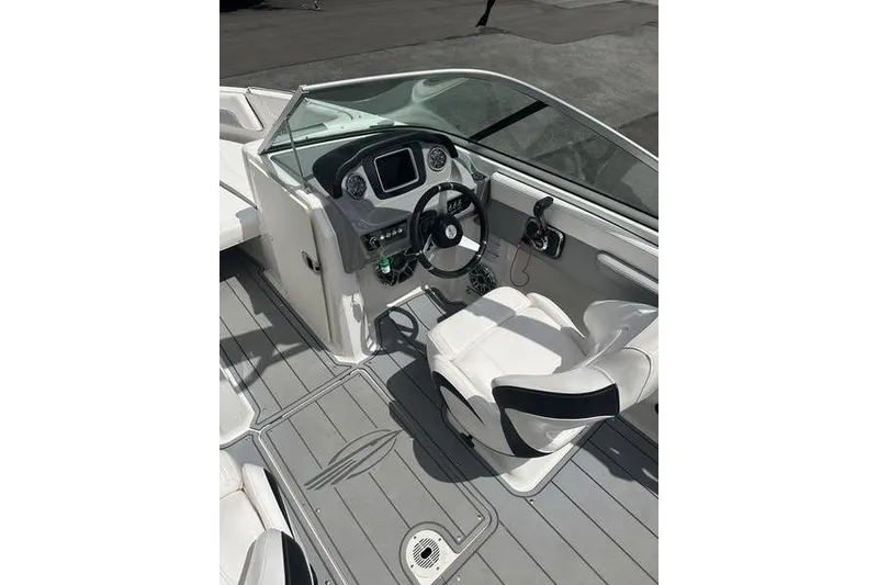 Slide: The Image of 2021 Chaparral 21 Surf boat interior with steering wheel and dashboard controls. - 8