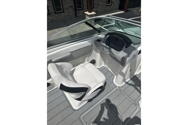 Slide: The Image of 2021 Chaparral 21 Surf boat interior with white seating and sleek dashboard design. - 9
