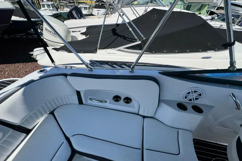Slide: The Image of 2026 Stingray 231 DC boat interior with cushioned seating and cup holders. - 10