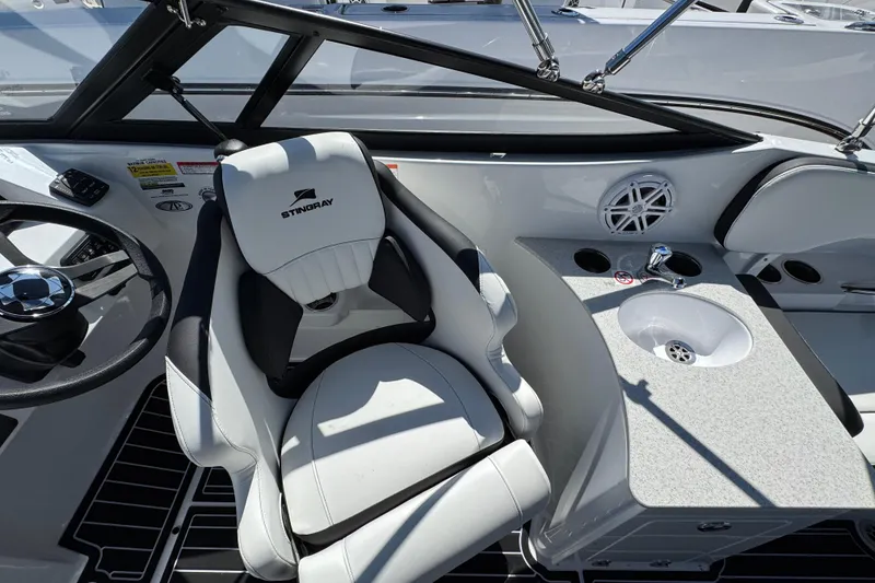Slide: The Image of Interior of 2026 Stingray 231 DC boat featuring helm seat and sink area. - 11