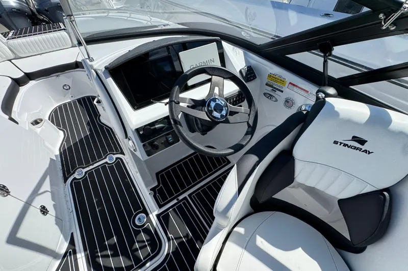 Slide: The Image of Interior view of 2026 Stingray 231 DC boat, featuring sleek dashboard and steering wheel. - 12