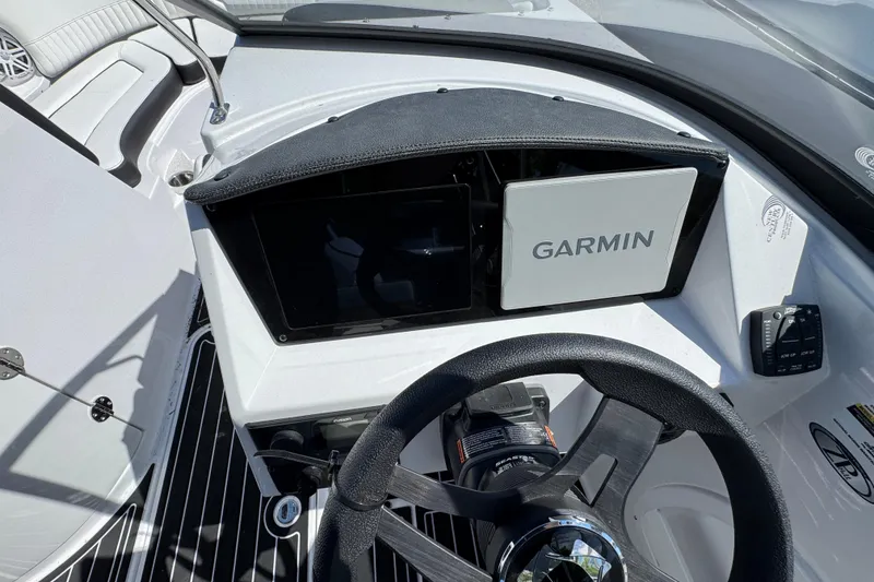 Slide: The Image of 2026 Stingray 231 DC boat dashboard with Garmin navigation system and steering wheel. - 14