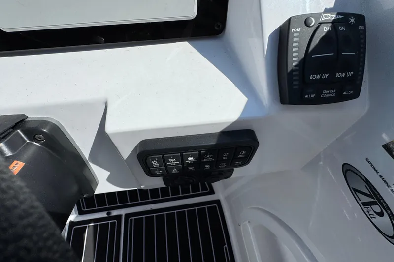 Slide: The Image of Control panel of 2026 Stingray 231 DC boat with trim tab controls and switches. - 16