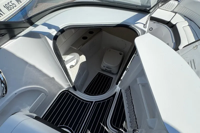 Slide: The Image of Interior view of 2026 Stingray 231 DC boat cabin with seating and storage. - 19