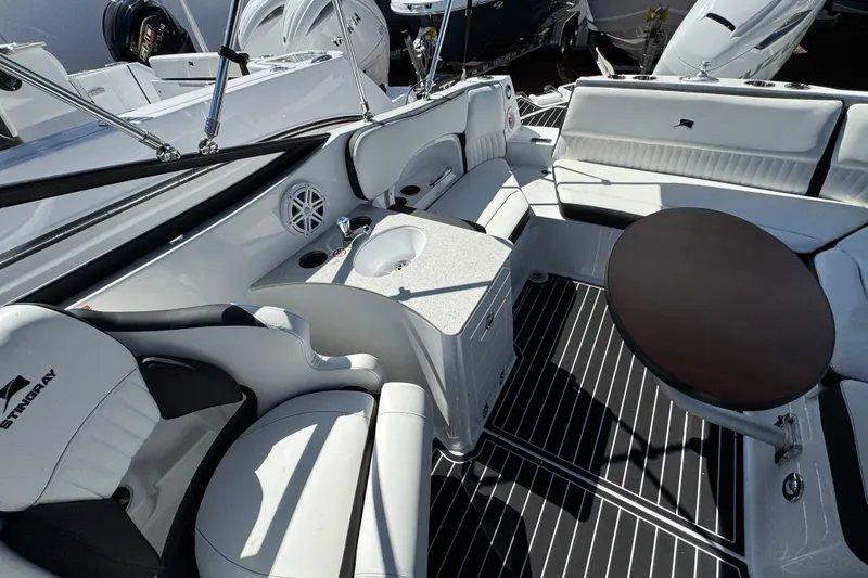 Slide: The Image of 2026 Stingray 231 DC boat interior with sleek seating, table, and modern amenities. - 31