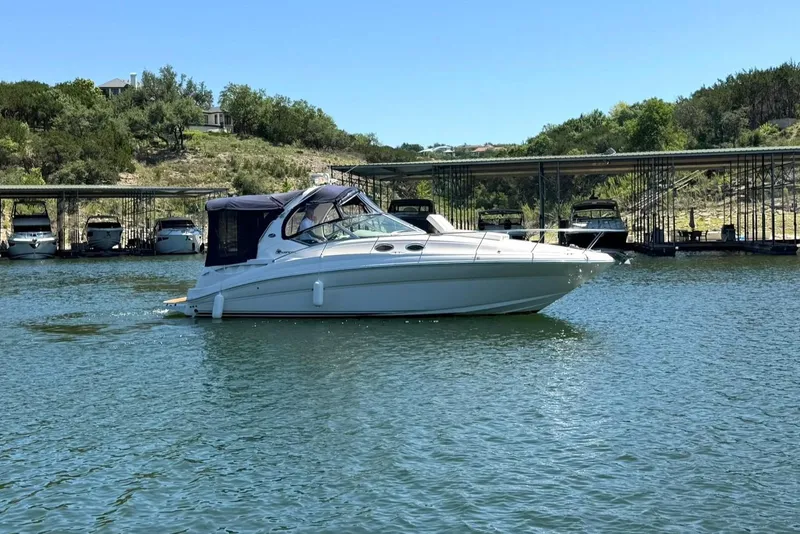 Slide: The Image of 2006 Sea Ray Sundancer 320 cruising on a serene lake near a marina. - 13