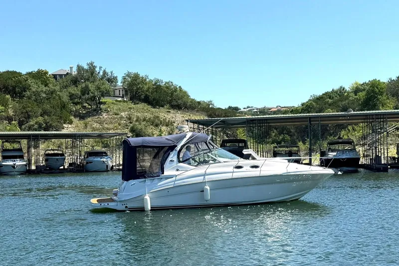 Slide: The Image of 2006 Sea Ray Sundancer 320 cruising on a serene lake near a marina. - 14