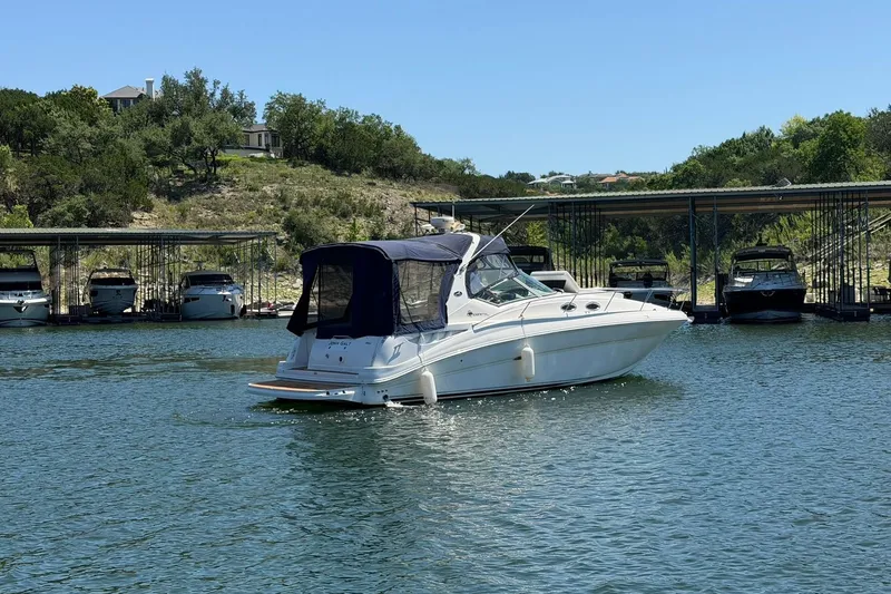 Slide: The Image of 2006 Sea Ray Sundancer 320 cruising on a serene lake near a marina. - 15