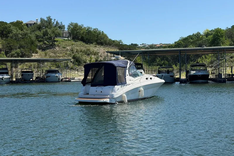 Slide: The Image of 2006 Sea Ray Sundancer 320 cruising near a marina with docked boats. - 16