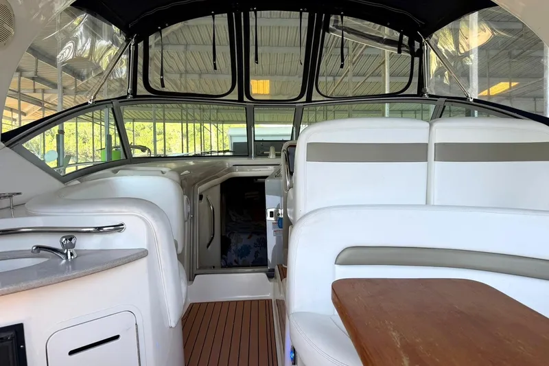 Slide: The Image of Interior of a 2006 Sea Ray Sundancer 320 yacht with white seating and wooden table. - 21