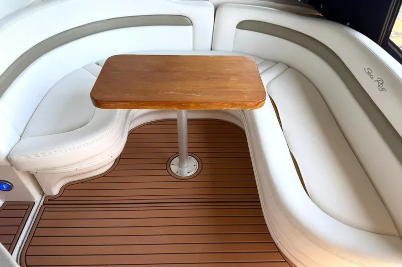 Slide: The Image of Interior of a 2006 Sea Ray Sundancer 320 with white seating and wooden table. - 22