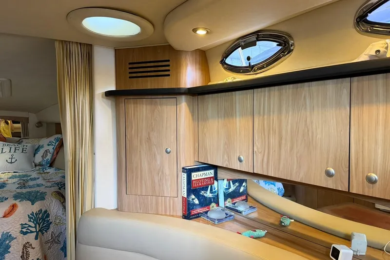 Slide: The Image of Interior of 2006 Sea Ray Sundancer 320 with wood cabinets and nautical-themed bedding. - 48