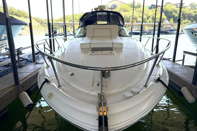 Slide: The Image of 2006 Sea Ray Sundancer 320 docked in a marina, showcasing sleek design and spacious deck. - 58