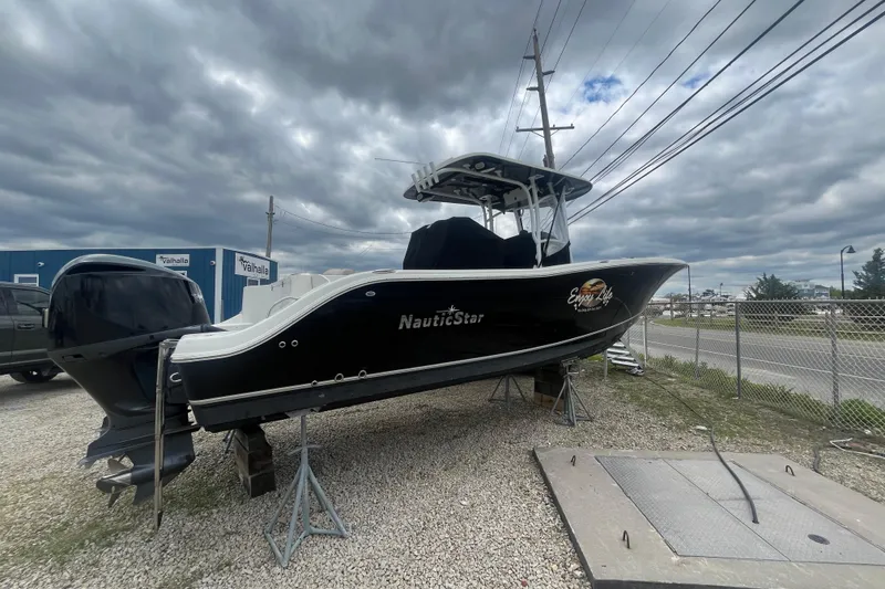 Slide: The Image of 2017 NauticStar 28 XS boat on stands under cloudy sky. - 14