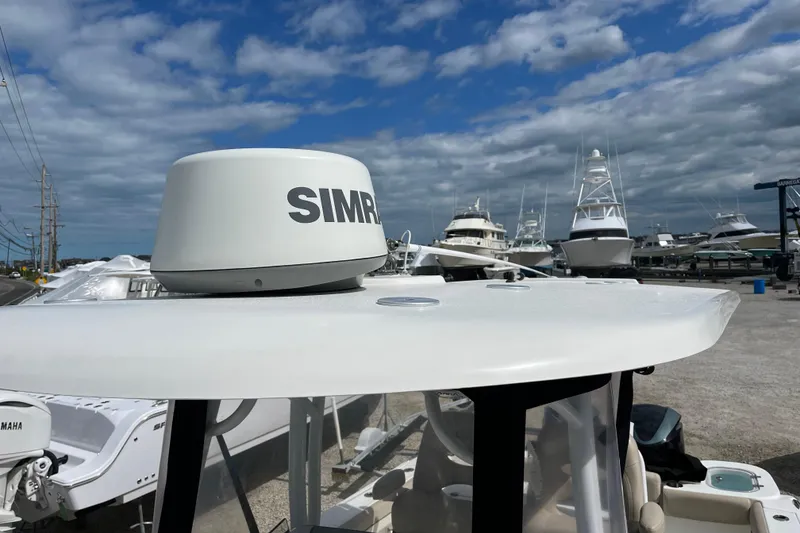 Slide: The Image of 2017 NauticStar 28 XS boat with Simrad radar, docked among other vessels under a cloudy sky. - 8