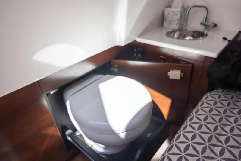 Slide: The Image of 2022 Chaparral 300 OSX boat interior with compact bathroom and sink. - 12