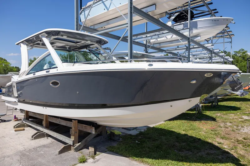 Slide: The Image of 2022 Chaparral 300 OSX boat on display in a marina storage area. - 2