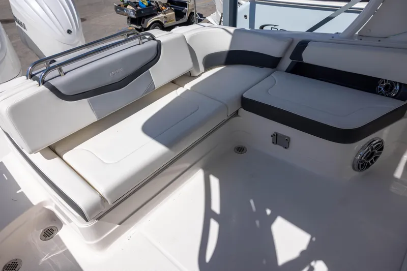 Slide: The Image of 2022 Chaparral 300 OSX boat interior with white cushioned seating and sleek design. - 7