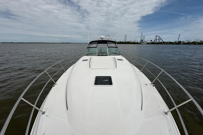 Slide: The Image of 2000 Sea Ray 410 Sundancer yacht on calm water with amusement park in background. - 26