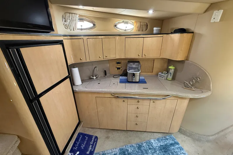 Slide: The Image of Interior of 2000 Sea Ray 410 Sundancer yacht kitchen with wooden cabinets and appliances. - 33