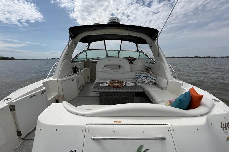 Slide: The Image of 2000 Sea Ray 410 Sundancer yacht interior with seating, table, and colorful cushions on open water. - 4