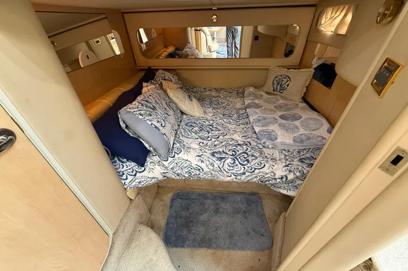 Slide: The Image of Cozy cabin interior of 2000 Sea Ray 410 Sundancer with patterned bedding and soft lighting. - 46