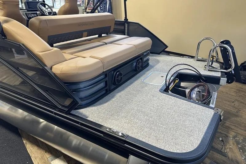 Slide: The Image of 2026 Bennington M Swingback 22 MSB boat interior with tan seating and storage compartment. - 8
