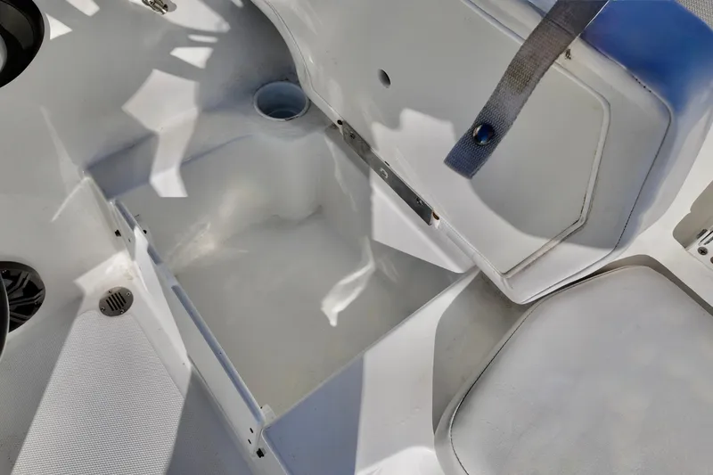 Slide: The Image of 2024 Tahoe T18 boat interior storage compartment with open lid and seating area. - 6