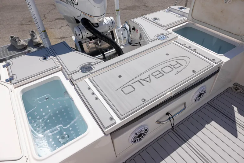 Slide: The Image of 2023 Robalo 266 Cayman boat deck with storage compartments and motor. - 6