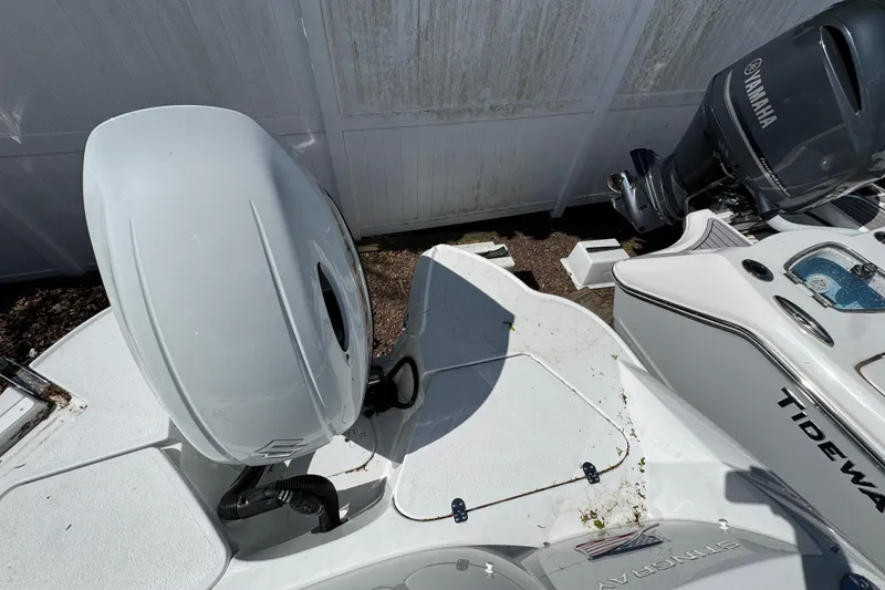 Slide: The Image of Stingray 211 DC 2026 boat with Yamaha outboard motor, parked near a white fence. - 10