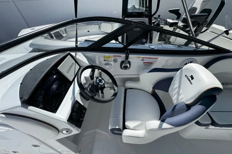 Slide: The Image of 2026 Stingray 211 DC boat interior with Garmin navigation and sleek steering wheel. - 12