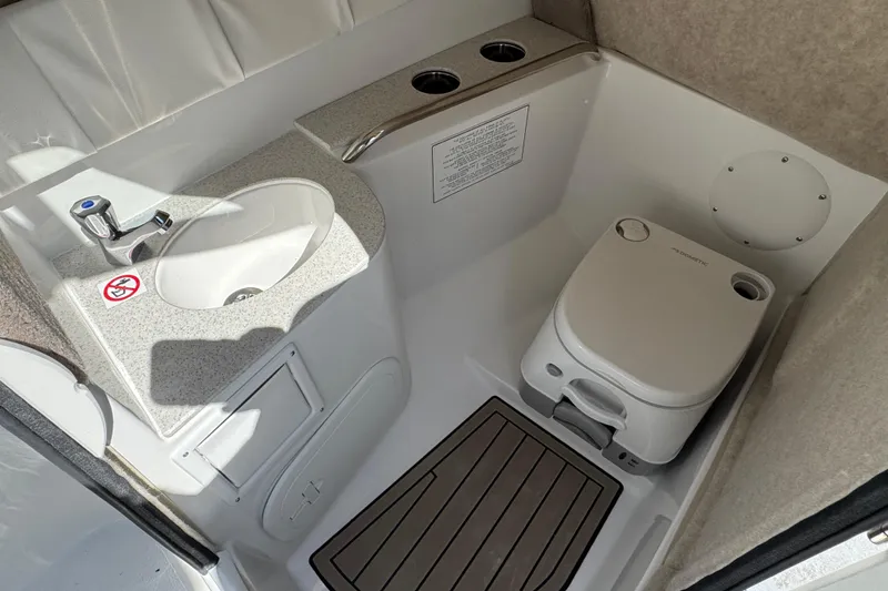 Slide: The Image of 2026 Stingray 211 DC boat bathroom with sink and portable toilet. - 18