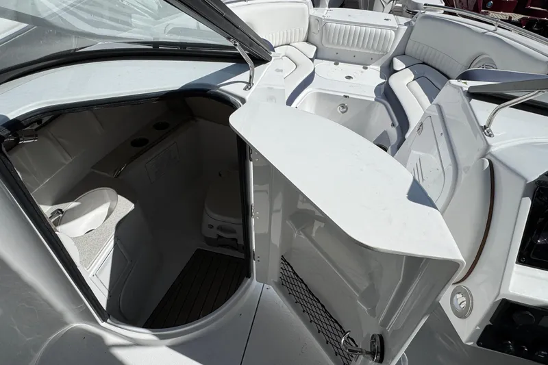 Slide: The Image of 2026 Stingray 211 DC boat interior with open storage compartment and seating area. - 20