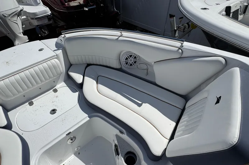 Slide: The Image of 2026 Stingray 211 DC boat interior with white cushioned seating and speaker. - 23