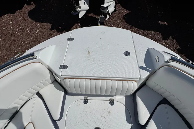 Slide: The Image of 2026 Stingray 211 DC boat interior with white cushioned seating and storage compartment. - 25