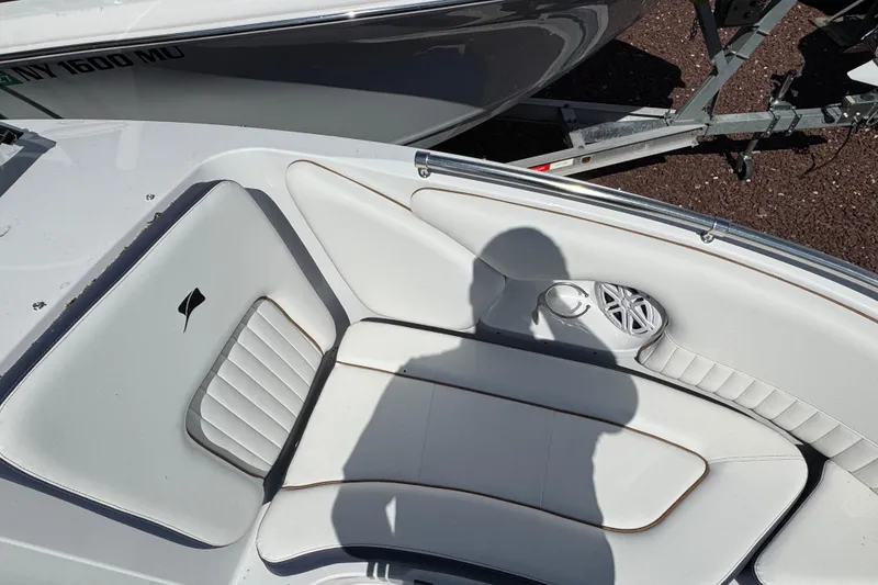 Slide: The Image of Interior of 2026 Stingray 211 DC boat with white seating and speaker detail. - 26