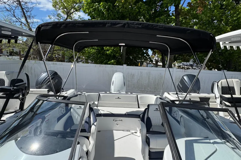 Slide: The Image of 2026 Stingray 211 DC boat with canopy, dual engines, and sleek seating in a sunny outdoor setting. - 29