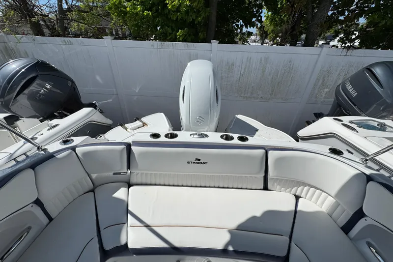 Slide: The Image of 2026 Stingray 211 DC boat interior with white seating and dual outboard motors. - 3