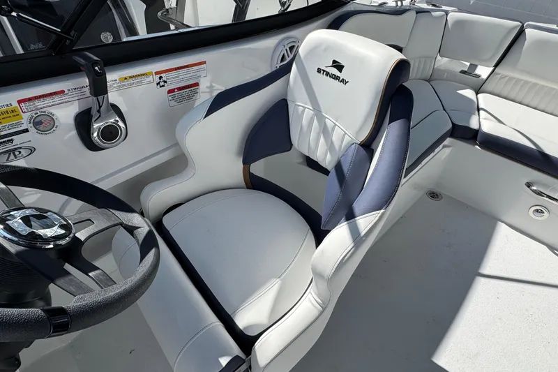 Slide: The Image of 2026 Stingray 211 DC boat interior with sleek white and navy seating design. - 30
