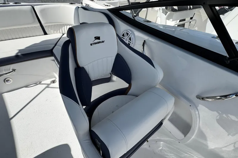 Slide: The Image of 2026 Stingray 211 DC boat interior with white and navy seating, showcasing luxury design. - 31