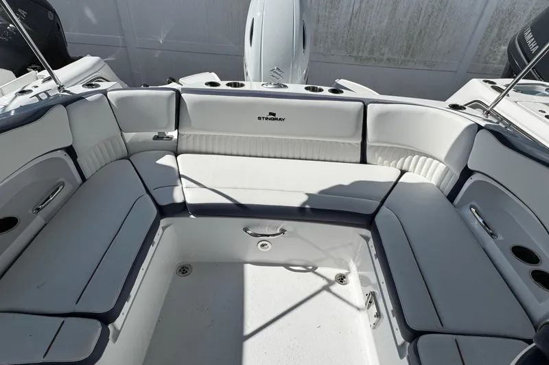 Slide: The Image of 2026 Stingray 211 DC boat interior with white cushioned seating and cup holders. - 32