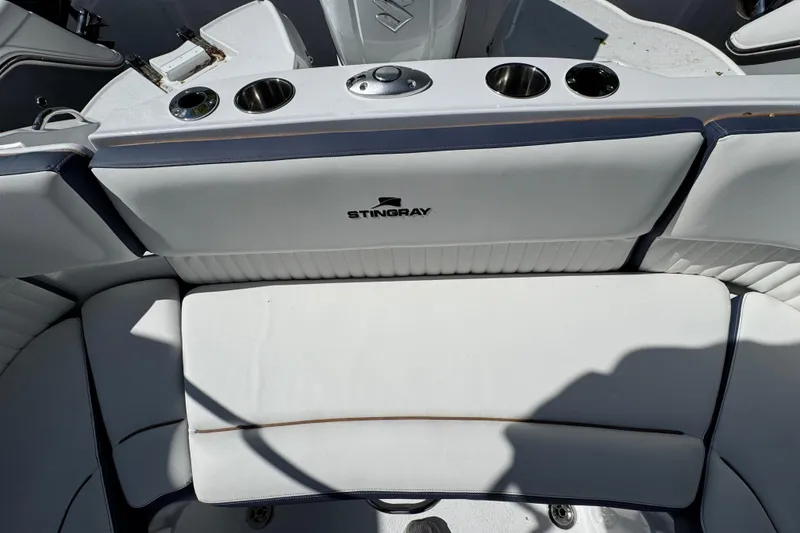 Slide: The Image of Interior seating of 2026 Stingray 211 DC boat with cup holders and logo. - 4