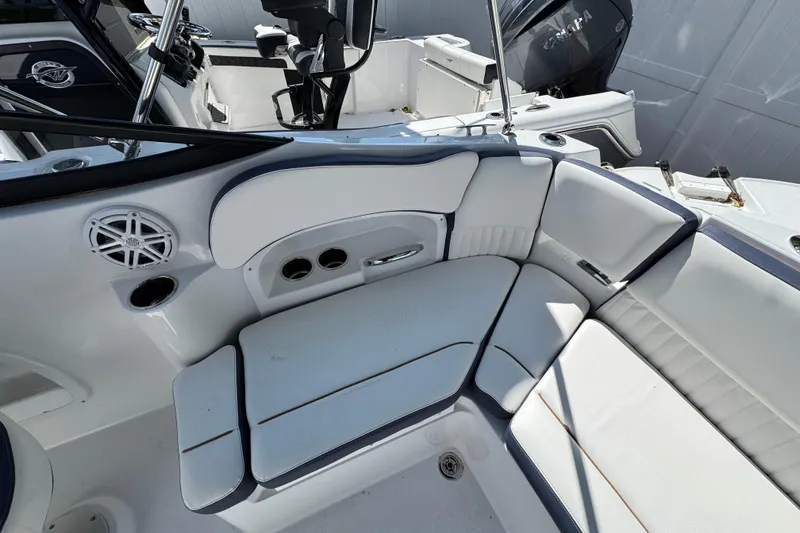 Slide: The Image of 2026 Stingray 211 DC boat interior with white cushioned seating and speaker system. - 5