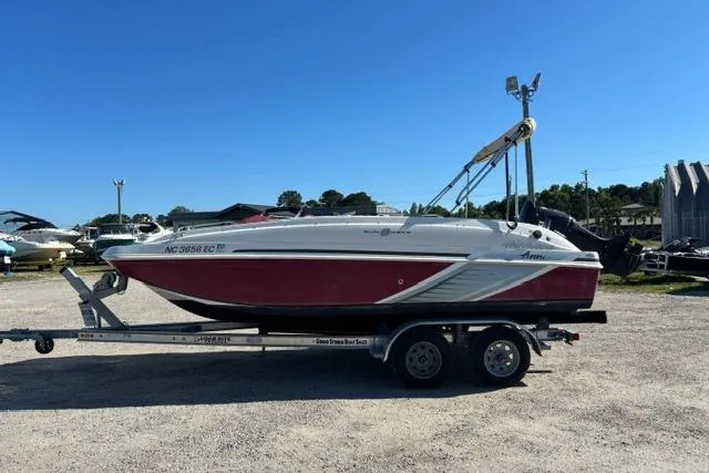 Slide: The Image of 2016 Hurricane SunDeck Sport 188 OB boat on trailer, parked outdoors under clear blue sky. - 12