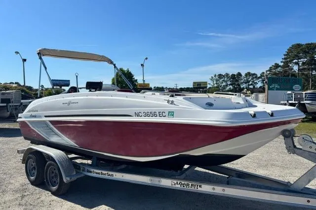 Slide: The Image of 2016 Hurricane SunDeck Sport 188 OB boat on trailer, red and white design, sunny day. - 17