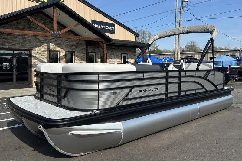 Slide: The Image of 2026 Bennington S Swingback 22 SSB pontoon boat parked outside dealership. - 14