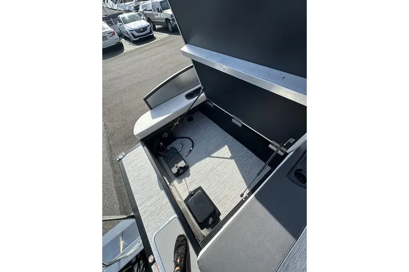 Slide: The Image of 2026 Bennington S Swingback 22 SSB boat interior storage compartment with open lid. - 18