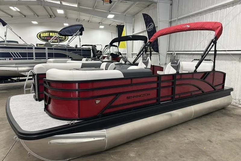 The Image of 2026 Bennington S Swingback 22 SSB pontoon boat with red accents in a showroom. - 1